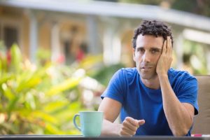 Man looking worried while drinking coffee.