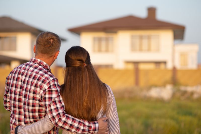 young couple standing together looking at their new house